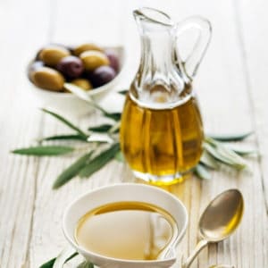 photo of a jar of olive oil, bowl of olive oil and bowl of olives representing Cobrançosa Extra Virgin Olive Oil