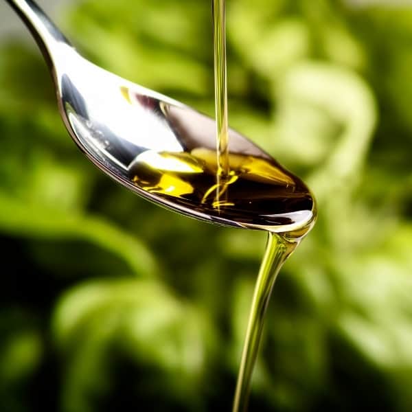 photo of spoon with olive oil being poured on it representing chiquitita extra virgin olive oil