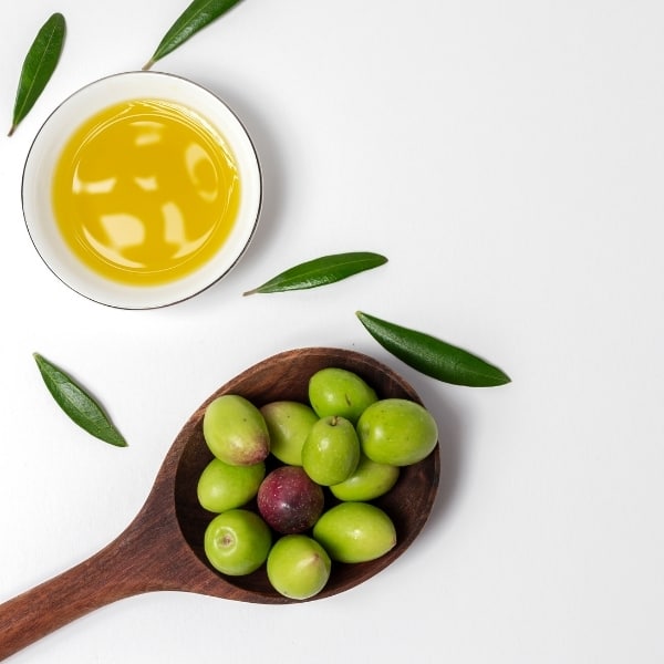 photo of bowl of olive oil and spoon with olives representing hojiblanca extra virgin olive oil