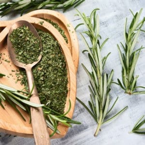 photo of dried rosemary in bowl with rosemary springs representing rosemary olive oil