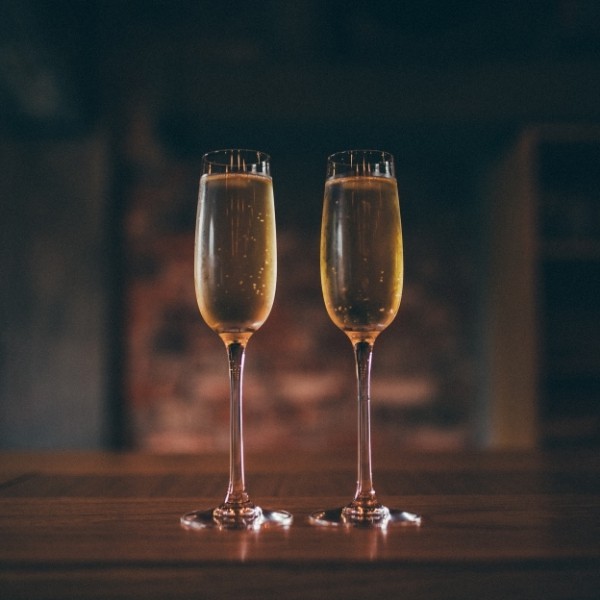 photo of two glasses of champagne with dark background representing champagne dark balsamic vinegar