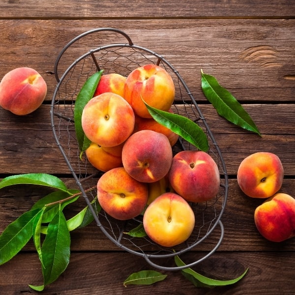 photo of peaches in wire basket representing peach white balsamic vinegar