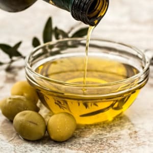 photo of olive oil in dish and green olives representing athinolia olive oil