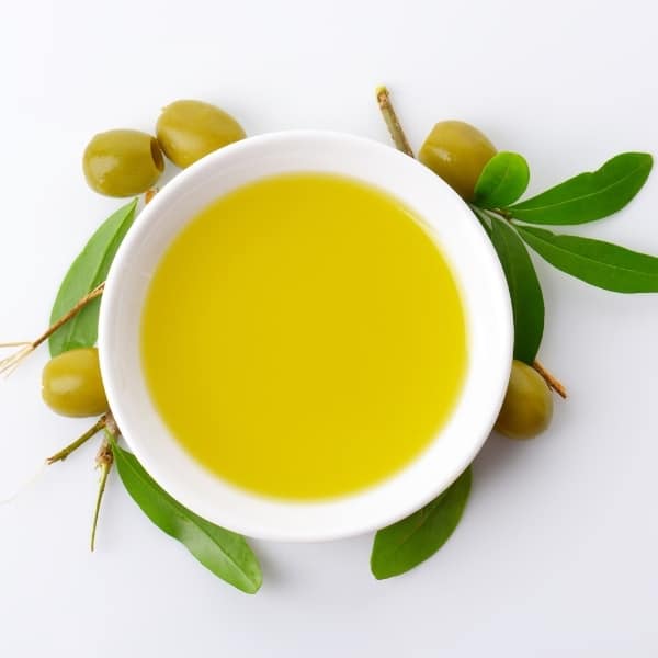 photo of bowl of olive oil surround by olives representing coratina extra virgin olive oil