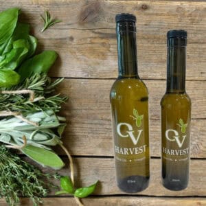A bunch of herbs and OV harvest olive oil bottles representing Tuscan Herb Olive Oil
