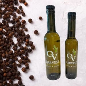 Black peppercorns and OV Harvest olive oil bottles representing Madagascar Black Pepper Olive Oil