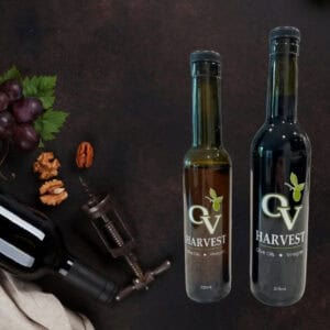 Bottle of wine, grapes, walnuts, wine opener and bottles of OV harvest balsamic vinegar representing Denissimo Balsamico