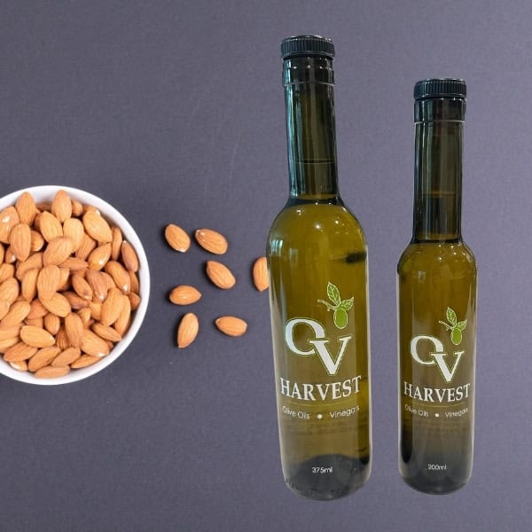Bowl of almonds and OV Harvest oil bottles representing Almond Oil