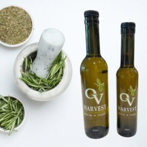 Bowl of dried herbs, bowl of rosemary, pestle and mortar and OV Harvest olive oil bottles representing Herbes de Provence Olive Oil