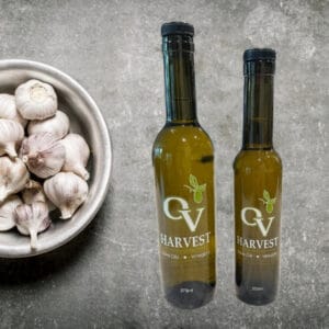 Bowl of garlic bulbs and OV Harvest olive oil representing Garlic Olive Oil