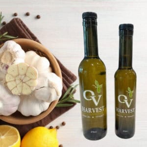 Bowl of garlic, lemons, herbs, spices and OV Harvest olive oil bottles representing Milanese Gremolata Olive Oil
