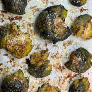 Baked and flattened brussels sprouts on a tray.