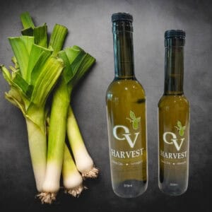 Bunch of leeks and OV Harvest olive oil bottles representing Leek Olive Oil
