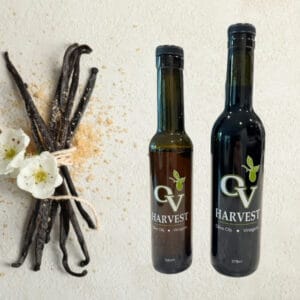 Bundle of vanilla sticks and OV Harvest balsamic vinegar bottles representing Tahitian Vanilla Balsamic Vinegar