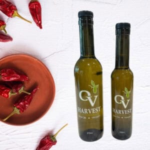 Chipotle peppers in a bowl and OV Harvest olive oil bottles representing Chipotle Olive Oil