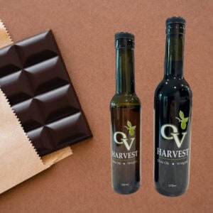 Dark chocolate bar in packaging and OV Harvest balsamic vinegar bottles representing Dark Chocolate Balsamic Vinegar