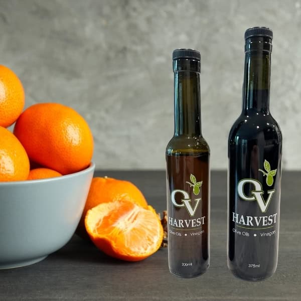 Gray bowl of tangerines and OV Harvest balsamic vinegar bottles representing Tangerine Balsamic Vinegar
