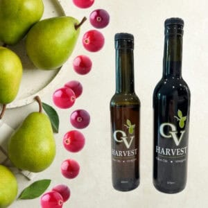 Green pears, cranberries and OV Harvest balsamic vinegar bottles representing Cranberry-Pear White Balsamic Vinegar