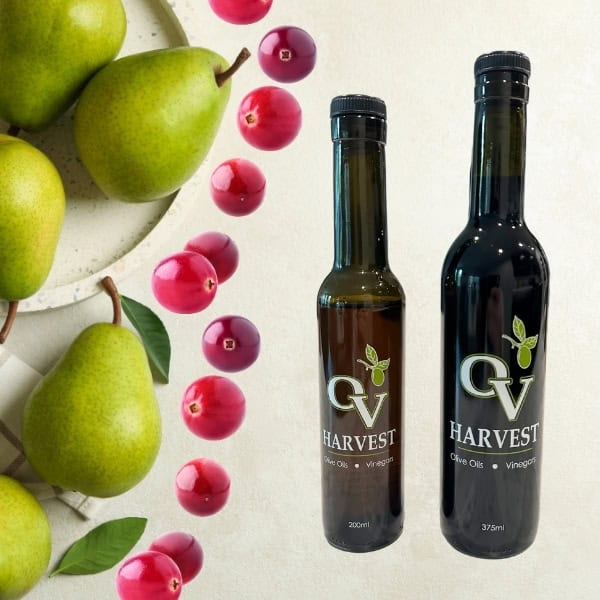 Green pears, cranberries and OV Harvest balsamic vinegar bottles representing Cranberry-Pear White Balsamic Vinegar