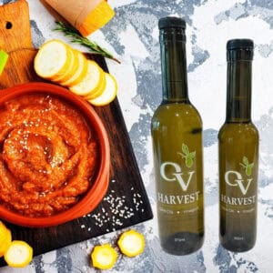 Harissa in a bowl, vegetables, and OV Harvest olive oil bottles representing Harissa Olive Oil