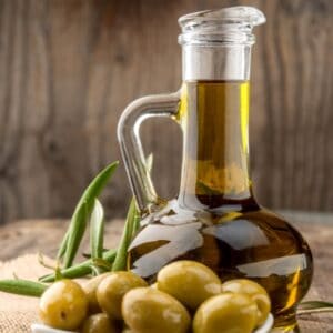 Jar of Olive Oil with olives representing Velagosht Robust Extra Virgin Olive Oil