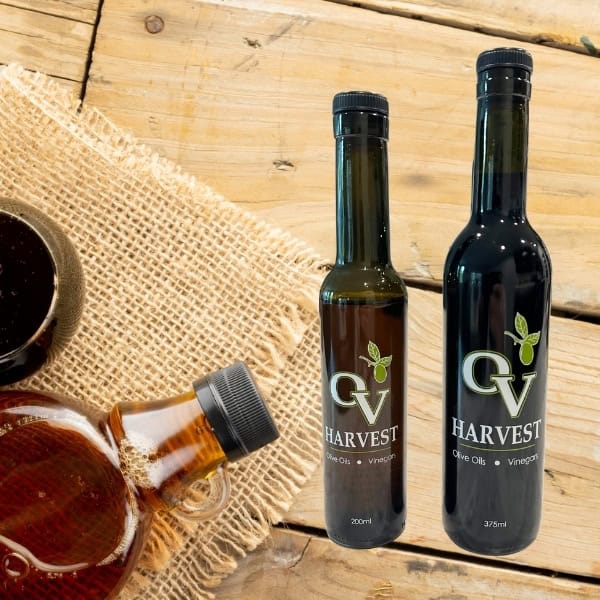 Jug of maple syrup, bowl of syrup and OV Harvest balsamic vinegar bottles representing Maple Balsamic Vinegar