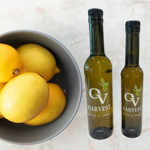 Lemons in a white bowl and OV Harvest olive oil bottles representing Eureka Lemon Olive Oil
