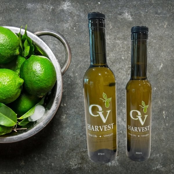 Limes in a bowl and OV Harvest olive oil bottles representing Persian Lime Olive Oil