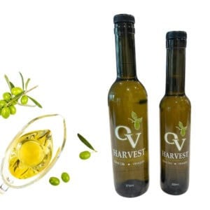 Pitcher of olive oil, olives and OV Harvest olive oil bottles representing Manzanillo Extra Virgin Olive Oil