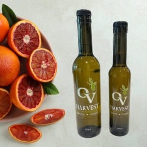 Plate with blood oranges and OV Harvest olive oil bottles representing Blood Orange Olive Oil