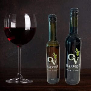Red wine glass and OV Harvest vinegar bottles representing Organic Red Wine Vinegar