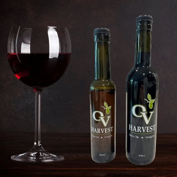 Red wine glass and OV Harvest vinegar bottles representing Organic Red Wine Vinegar