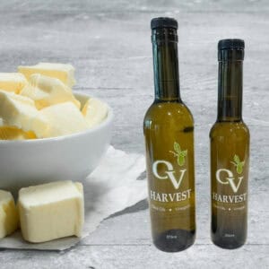 Sliced butter in a bowl and OV Harvest olive oil bottles representing Butter Olive Oil