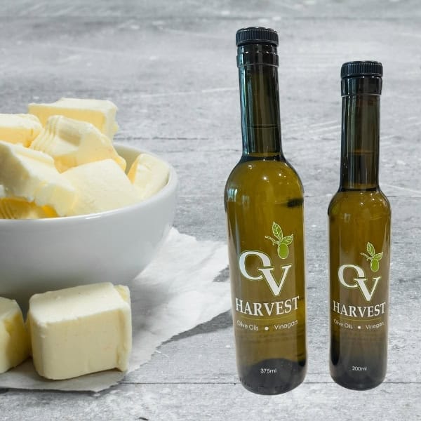 Sliced butter in a bowl and OV Harvest olive oil bottles representing Butter Olive Oil
