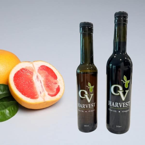 Sliced grapefruit and OV Harvest balsamic vinegar bottles representing Grapefruit White Balsamic Vinegar