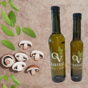 Sliced mushrooms, sage, and OV Harvest olive oil bottles representing Wild Mushroom & Sage Olive Oil