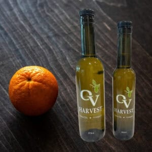 Sliced oranges and OV Harvest olive oil bottles representing Navel Orange Olive Oil