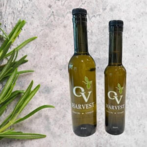 Sprigs of rosemary and OV Harvest olive oil bottles representing Rosemary Olive Oil