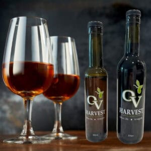 Two glasses of Sherry Wine and OV Harvest vinegar bottles representing Sherry Reserva Wine Vinegar