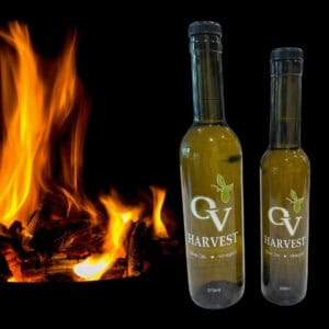 Wood fire and OV Harvest olive oil bottles representing Olive Wood Smoked Olive Oil